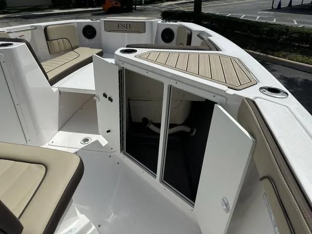 Slide: The Image of 2024 Yamaha Boats 222 FSH Sport E interior seating and storage area. - 18