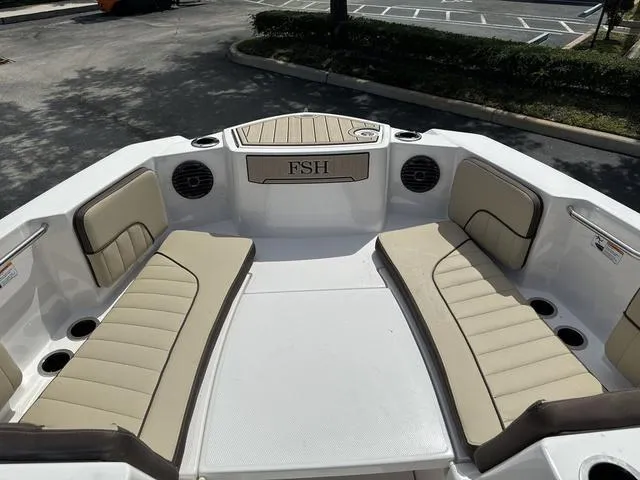 Slide: The Image of Storage compartment on a 2024 Yamaha Boats 222 FSH Sport E with a white bucket inside. - 12