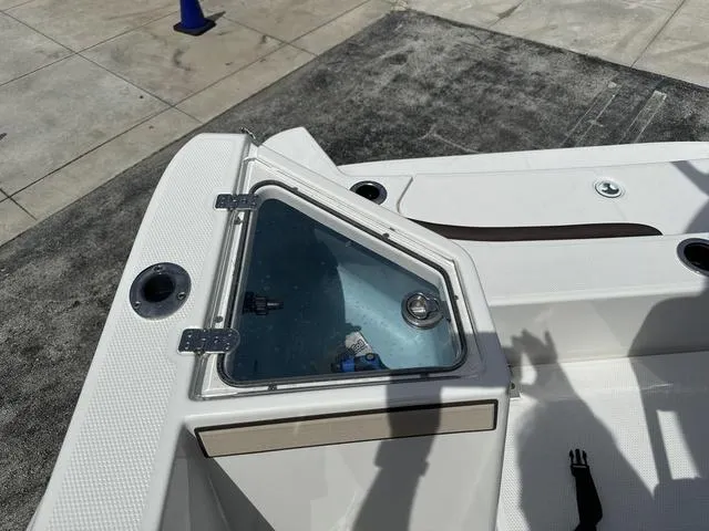 Slide: The Image of 2024 Yamaha Boats 222 FSH Sport E interior console with rod holders and steering wheel. - 17