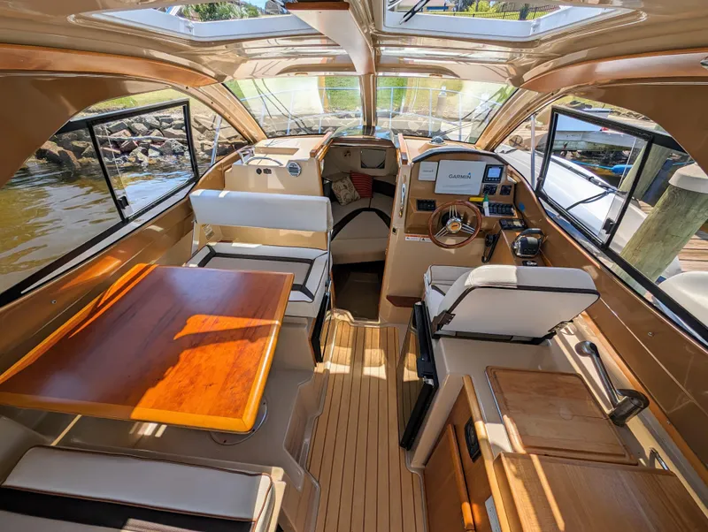 Slide: The Image of Interior of a 2016 Cutwater 24 boat with wooden table and seating. - 11