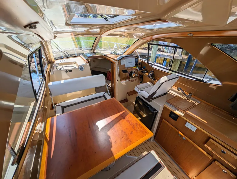 Slide: The Image of Interior of a 2016 Cutwater 24 boat with wooden table and seating. - 12