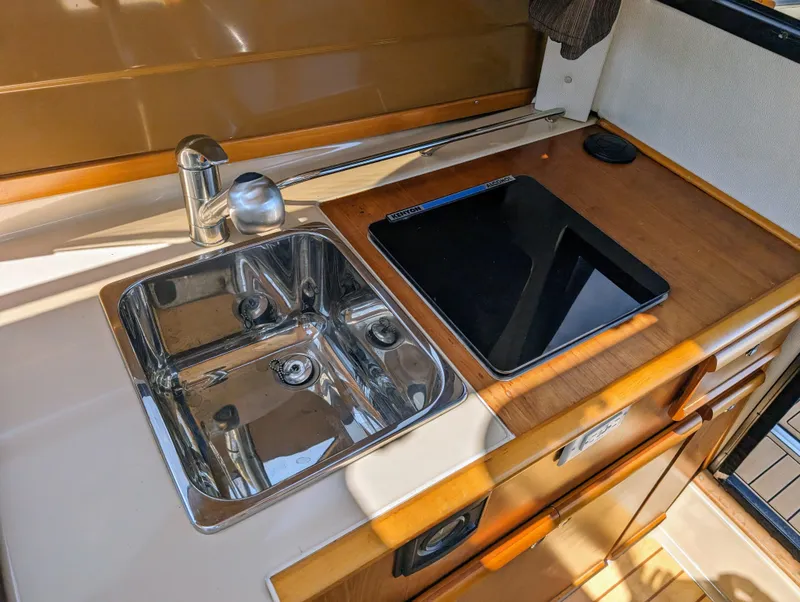 Slide: The Image of Compact kitchen area in a 2016 Cutwater 24 boat with sink and stove. - 17