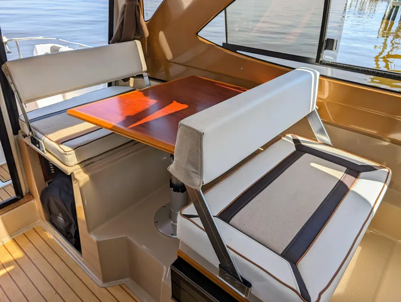 Slide: The Image of Interior seating area of a 2016 Cutwater 24 boat with wooden table. - 20