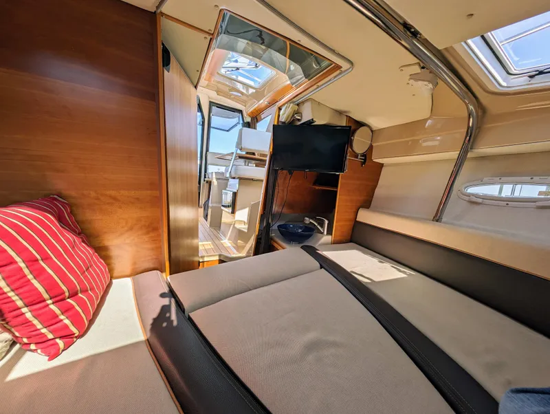 Slide: The Image of Interior of a 2016 Cutwater 24 boat with cozy seating and a TV. - 24