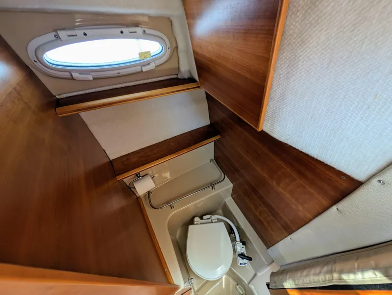 Slide: The Image of 2016 Cutwater 24 boat bathroom with wooden interior and porthole window. - 25