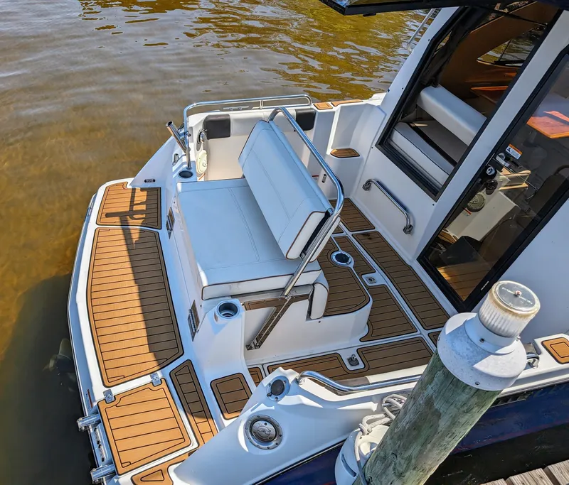 Slide: The Image of 2016 Cutwater 24 boat with teak deck and white seating at dock. - 4