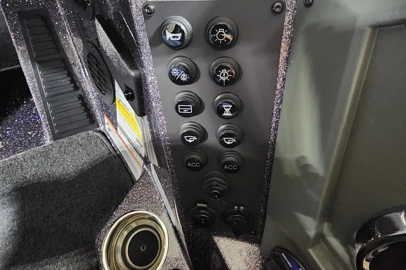 Slide: The Image of Control panel of 2024 Ranger Z518 boat with various switches and cup holder. - 8