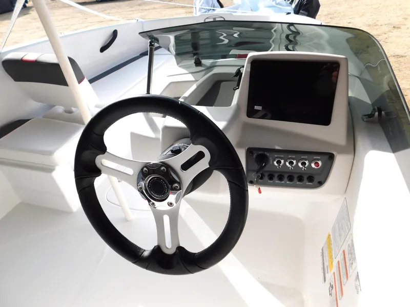 Slide: The Image of 2024 Tahoe T16 boat dashboard with steering wheel and control panel. - 10