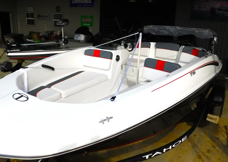 Slide: The Image of 2024 Tahoe T16 boat with sleek white design and red accents in showroom. - 12