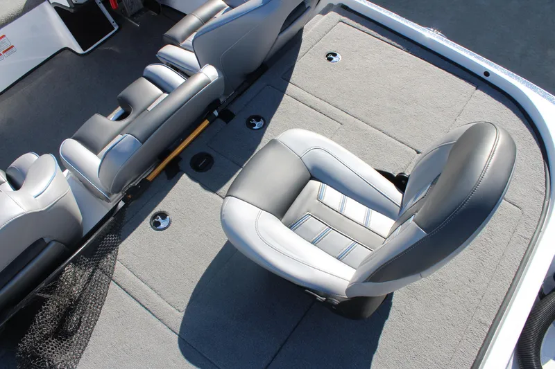Slide: The Image of 2024 Nitro Z20 boat interior with gray and black seating and carpeted flooring. - 12