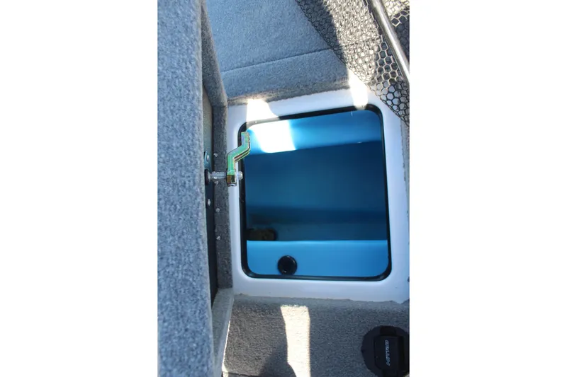 Slide: The Image of 2024 Nitro Z20 boat storage compartment with blue interior and secure latch. - 13