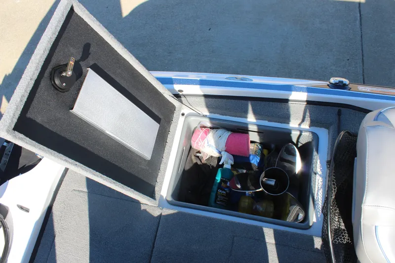 Slide: The Image of Open storage compartment in 2024 Nitro Z20 boat, containing various boating accessories. - 14