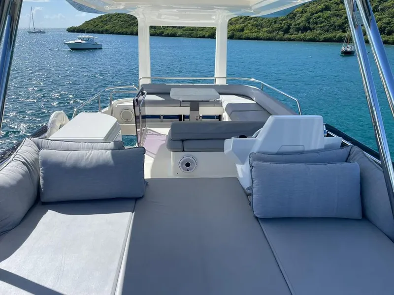 Slide: The Image of 2016 Ferretti Yachts 550 model, luxurious deck with seating, anchored in serene blue waters. - 7
