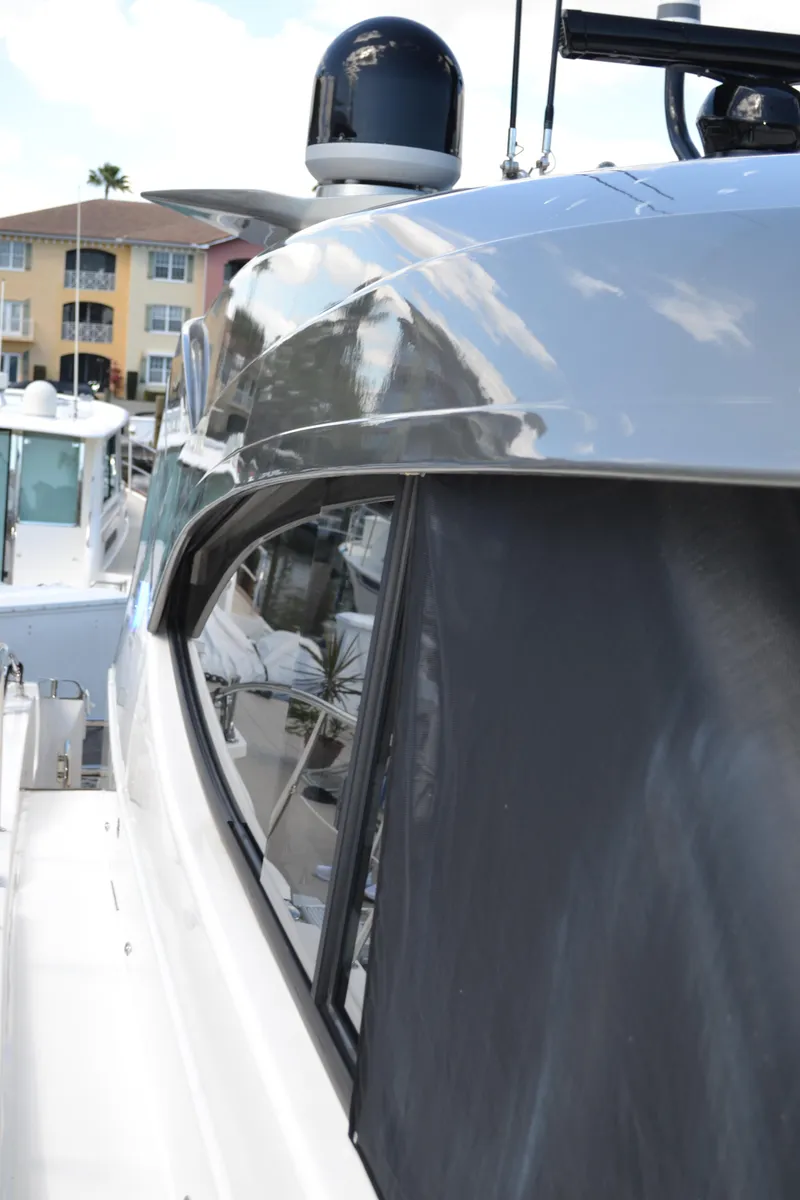 Slide: The Image of 2022 Riviera Sport Yacht 5400 Platinum Edition, sleek design, docked near waterfront buildings. - 14