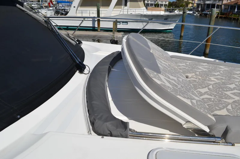 Slide: The Image of 2022 Riviera Sport Yacht 5400 Platinum Edition with sunpad, docked in marina. - 18