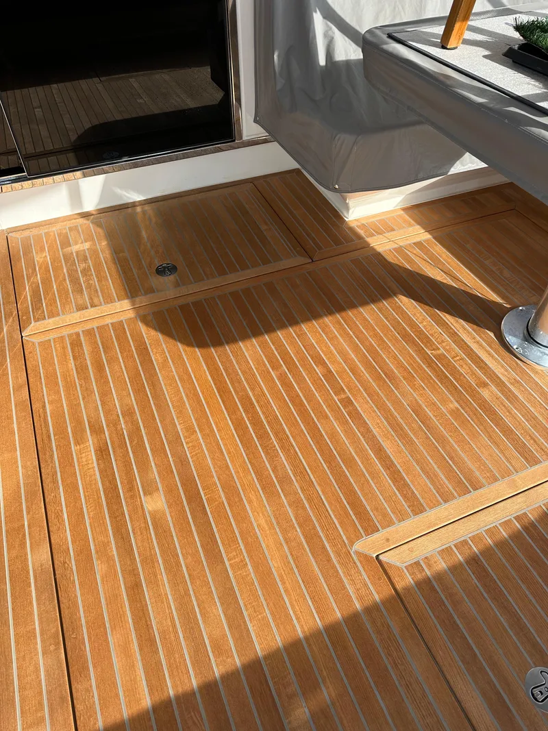 Slide: The Image of Teak deck of 2022 Riviera Sport Yacht 5400 Platinum Edition, showcasing elegant wood finish. - 24