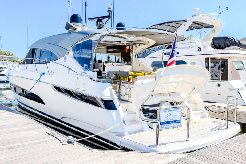 Slide: The Image of 2022 Riviera Sport Yacht 5400 Platinum Edition docked at marina, sleek design, luxury features. - 25