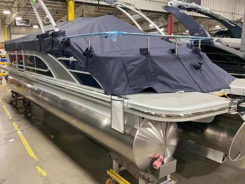 Slide: The Image of 2024 Bennington 24 LSBA pontoon boat in a warehouse, covered with a protective tarp. - 3
