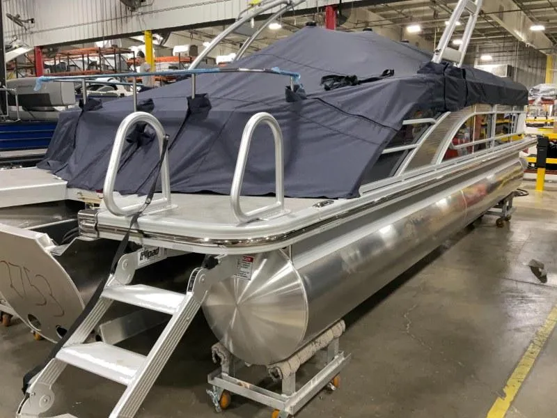Slide: The Image of 2024 Bennington 24 LSBA pontoon boat in a warehouse, partially covered. - 4
