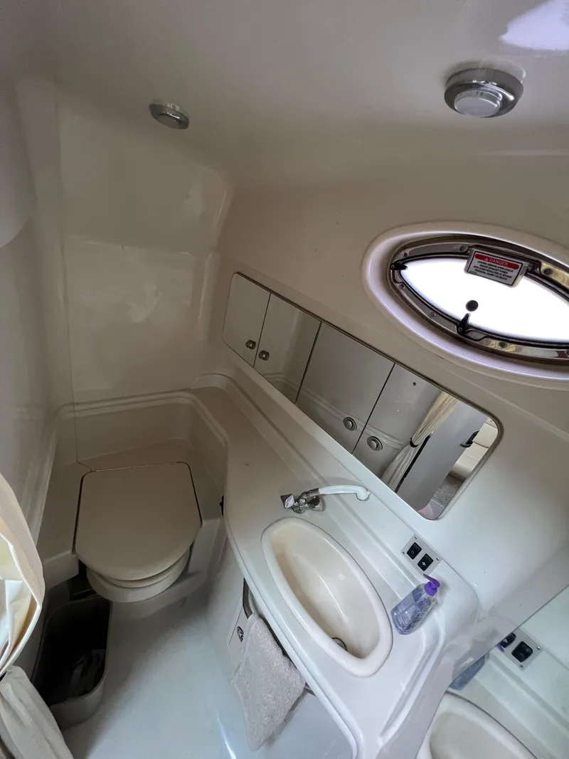 Slide: The Image of 2006 Sea Ray 340 Sundancer bathroom with sink, toilet, and porthole window. - 14