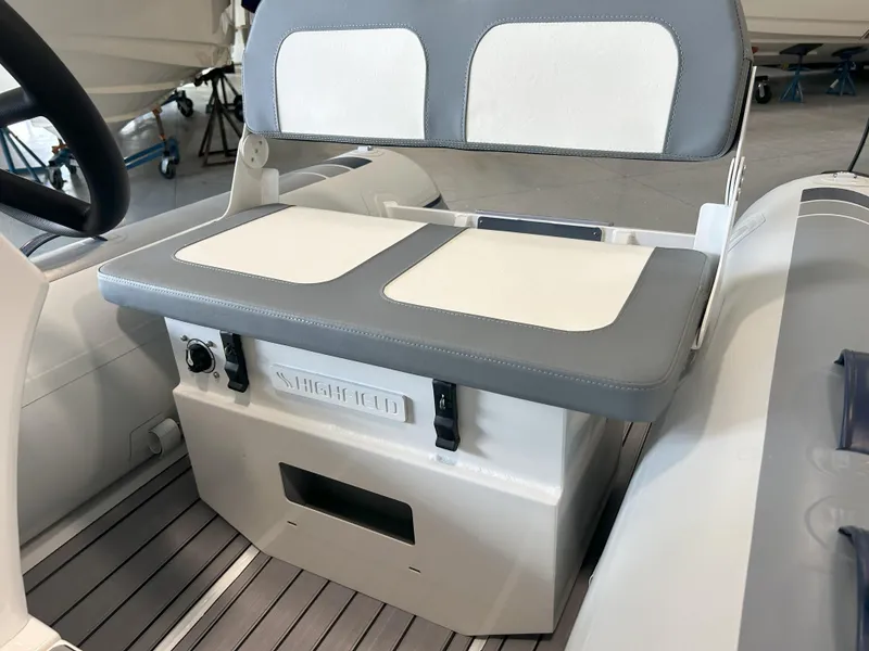 Slide: The Image of 2024 Highfield Classic 360 boat interior with cushioned seating and storage compartment. - 8