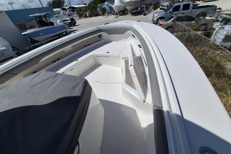 Slide: The Image of 2024 Regulator 37 boat deck with open storage compartments, parked in a marina. - 17