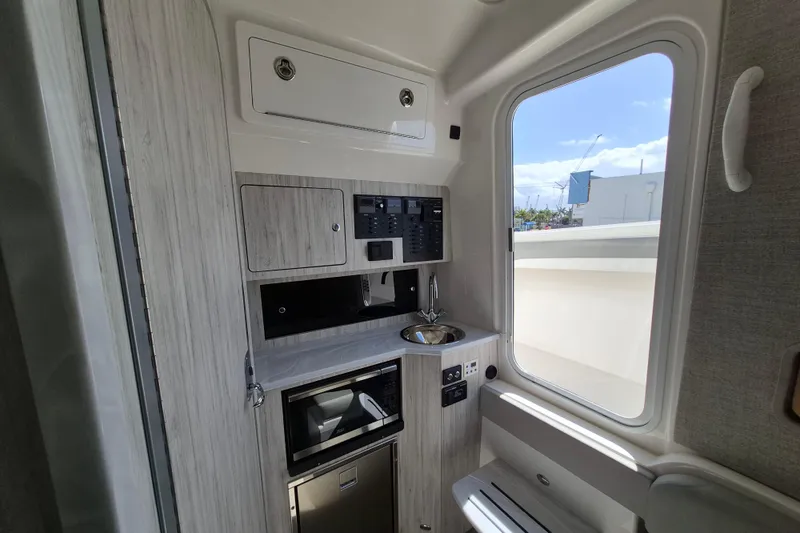 Slide: The Image of 2024 Regulator 37 interior with kitchenette, sink, and window view. - 19