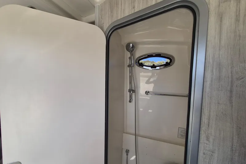Slide: The Image of 2024 Regulator 37 boat shower interior with porthole and modern fixtures. - 21