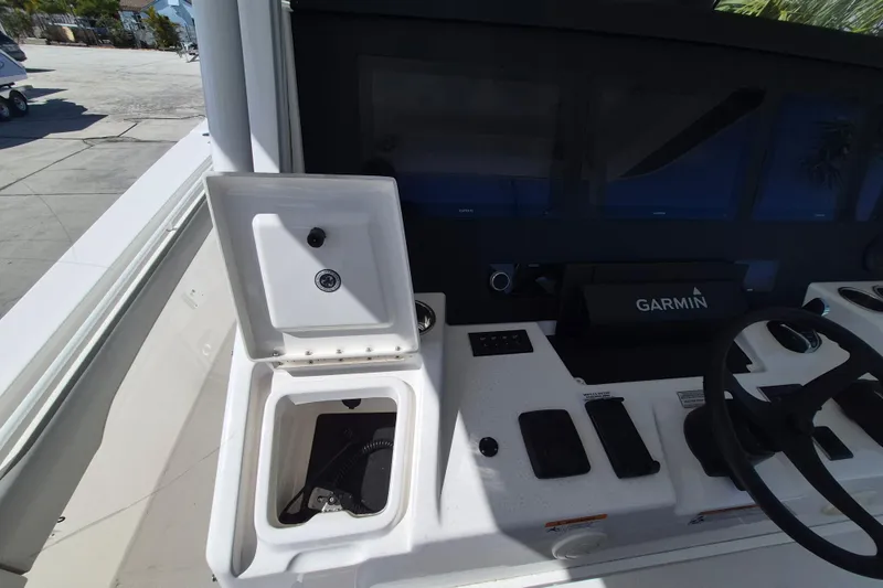 Slide: The Image of 2024 Regulator 37 boat dashboard with Garmin navigation system and open storage compartment. - 24