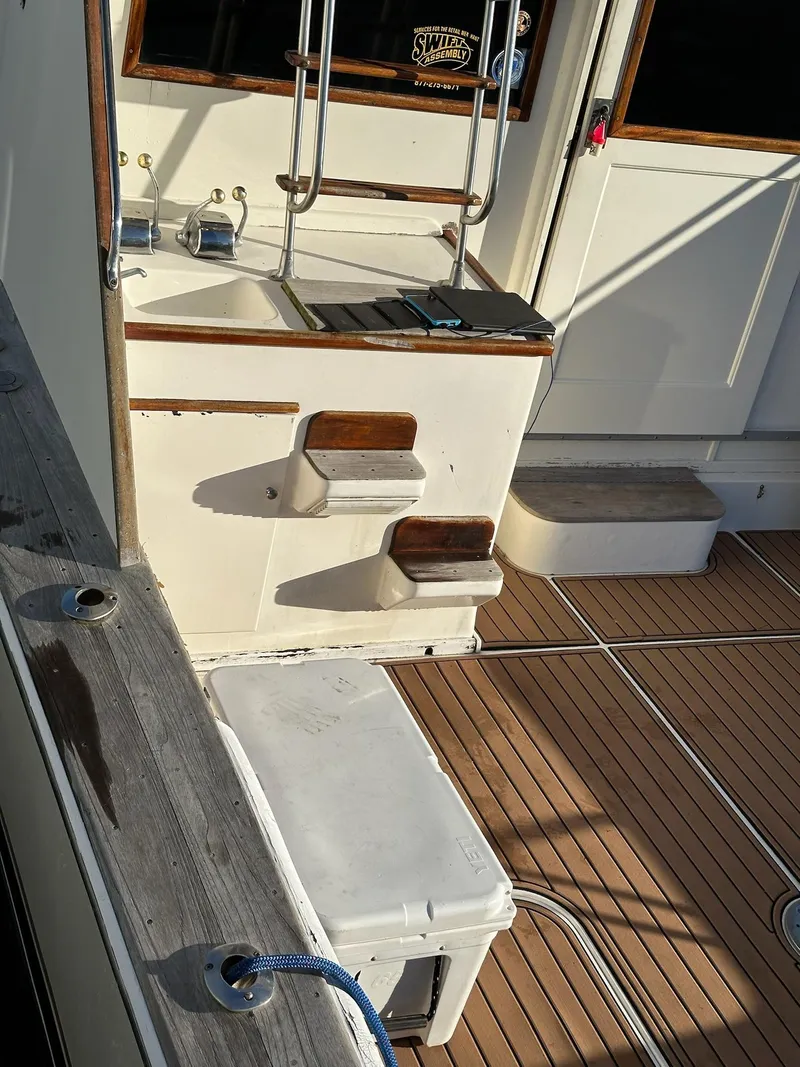 Slide: The Image of 1987 Post 46 SPORT boat deck with steps, cooler, and wooden flooring. - 30