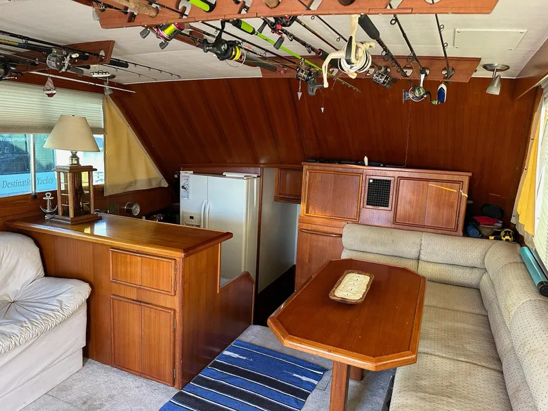 Slide: The Image of Interior of 1987 Post 46 SPORT yacht with fishing rods, wooden furniture, and cozy seating. - 15