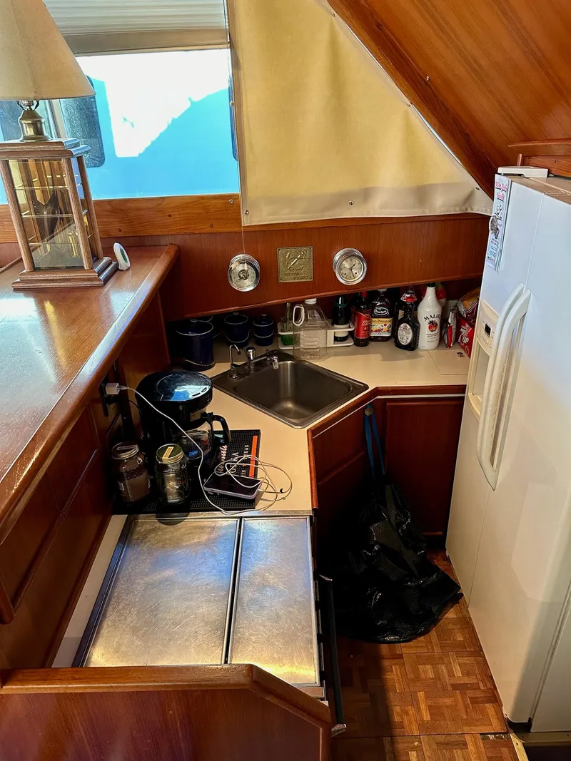 Slide: The Image of 1987 Post 46 SPORT yacht kitchen with sink, fridge, and wooden cabinetry. - 17