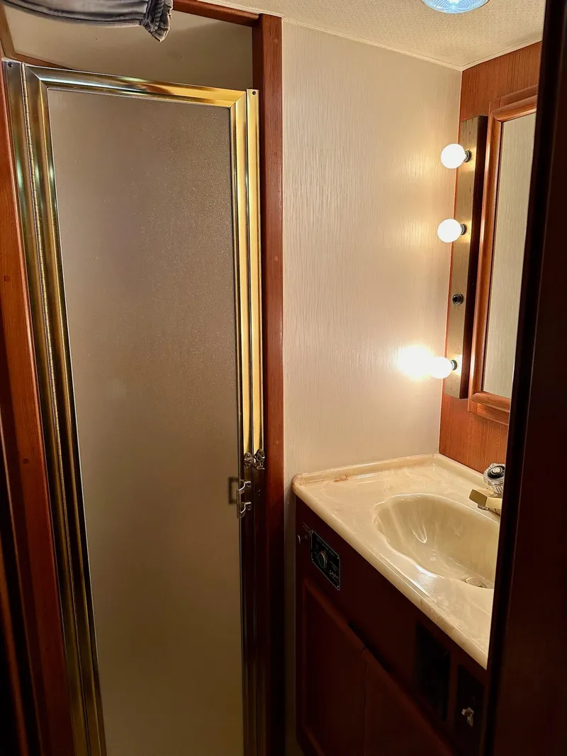 Slide: The Image of 1987 Post 46 SPORT yacht bathroom with shower, vanity, and mirror lighting. - 24