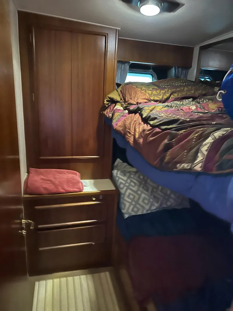 Slide: The Image of Cozy cabin interior of 1987 Post 46 SPORT with wooden cabinetry and colorful bedding. - 26