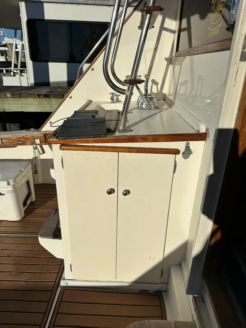 Slide: The Image of 1987 Post 46 SPORT yacht deck with wooden cabinetry and fishing rod holders. - 29