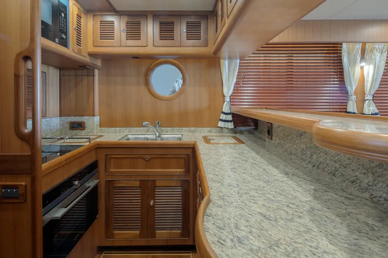 Slide: The Image of Luxurious 2026 Selene 49 Classic Explorer yacht kitchen with wood cabinetry and granite countertops. - 15