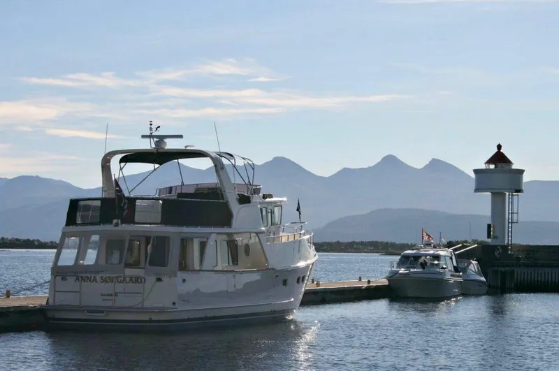 Slide: The Image of Selene 49 Classic Explorer yacht docked near lighthouse, scenic mountain backdrop, 2026 model. - 6