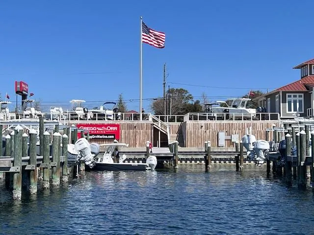 Slide: The Image of Marina with 2024 Sea Fox 251 Bay Fox boats, American flag, clear blue sky. - 16