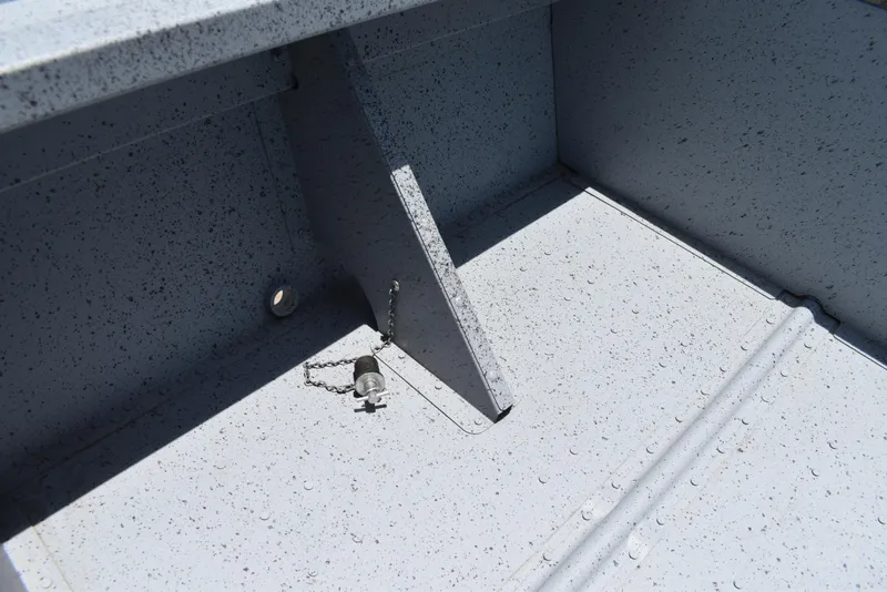 Slide: The Image of Interior of 2024 Lowe WV 1470 boat showing drain plug and textured surface. - 10
