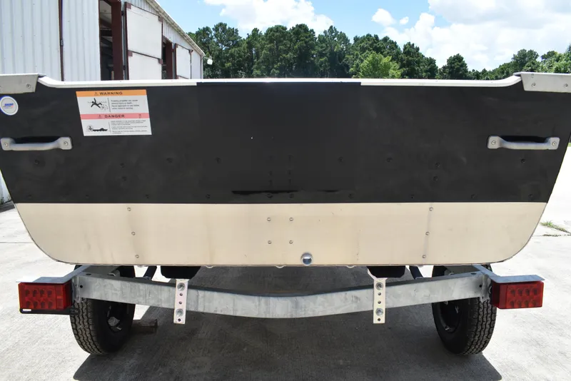 Slide: The Image of Rear view of a 2024 Lowe WV 1470 boat on a trailer, outdoors. - 2