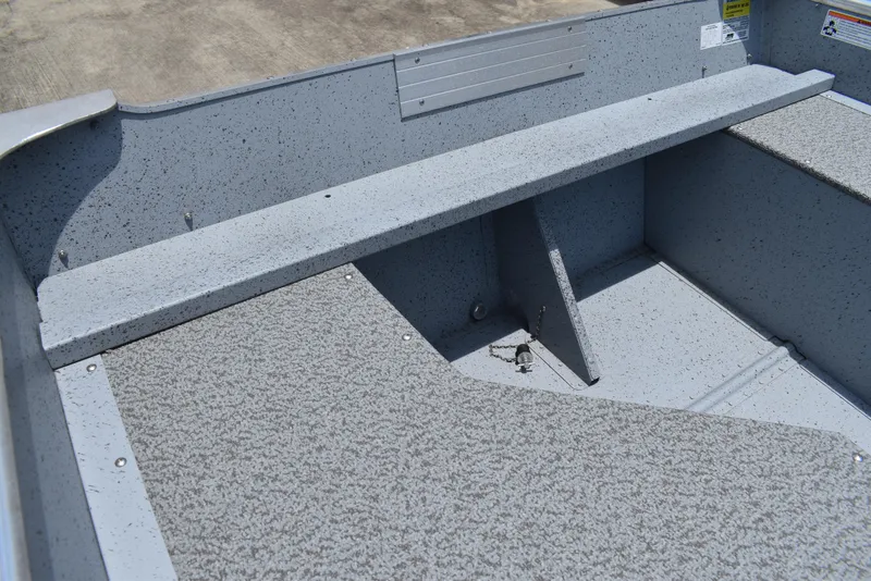 Slide: The Image of Interior of 2024 Lowe WV 1470 boat, featuring speckled gray flooring and seating. - 9