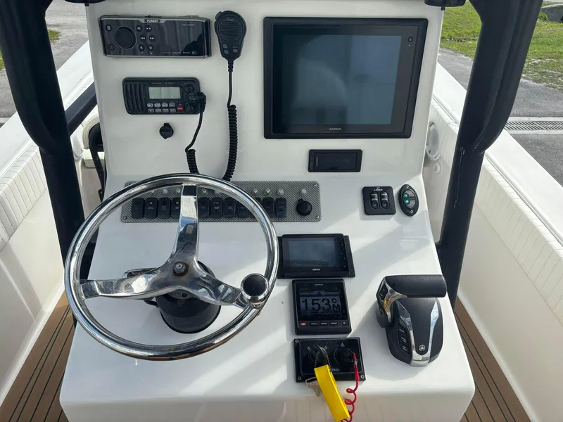 Slide: The Image of 2014 Andros Tarpon 26 boat console with steering wheel, navigation, and control systems. - 12