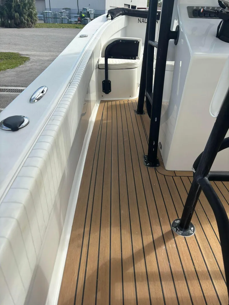 Slide: The Image of 2014 Andros Tarpon 26 boat deck with teak flooring and white interior. - 13