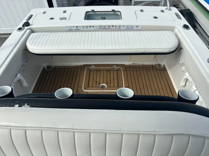 Slide: The Image of 2014 Andros Tarpon 26 boat interior with white seating and teak flooring. - 18