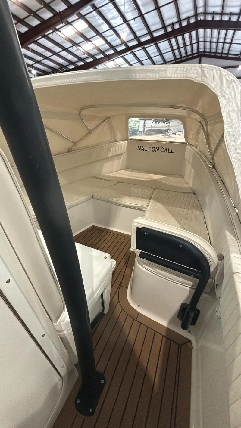 Slide: The Image of 2014 Andros Tarpon 26 boat interior with cushioned seating and wooden flooring. - 7