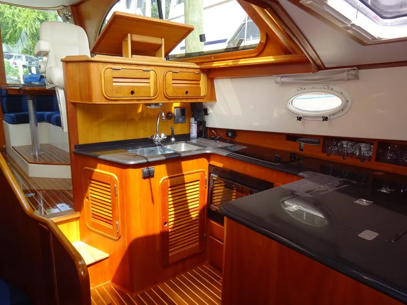 Slide: The Image of Luxurious 2002 Hinckley Talaria 44 FB yacht interior with elegant wood cabinetry and modern amenities. - 18