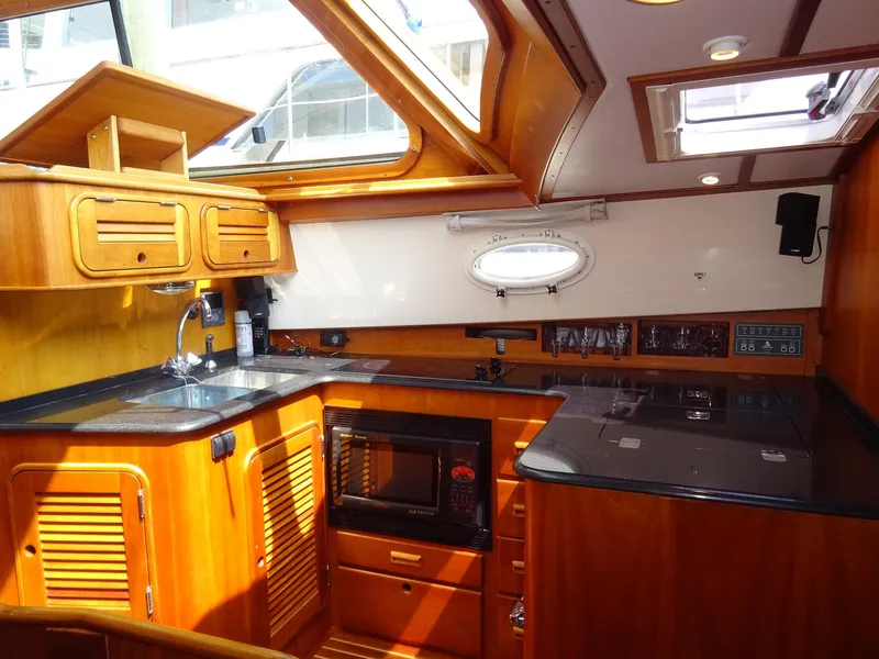 Slide: The Image of Hinckley Talaria 44 FB 2002 yacht interior with wooden cabinetry and modern kitchen amenities. - 19