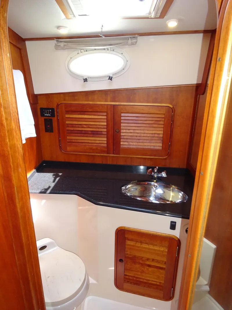 Slide: The Image of 2002 Hinckley Talaria 44 FB yacht bathroom with wood accents and stainless steel sink. - 24