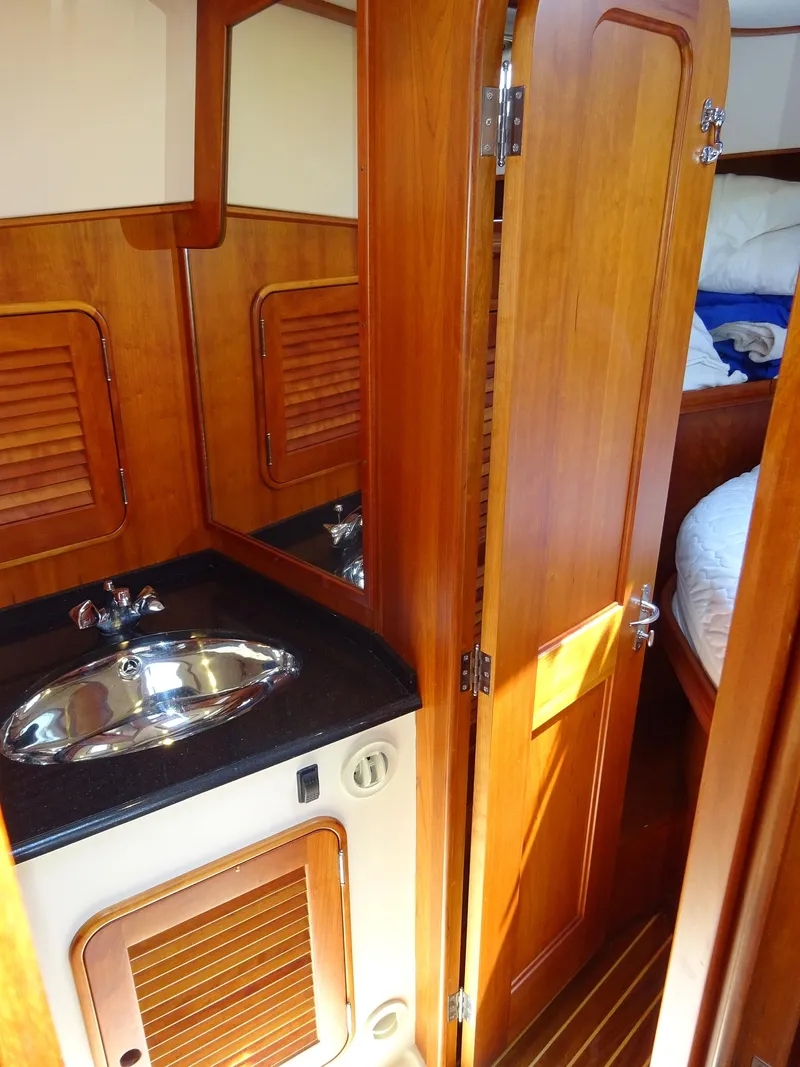 Slide: The Image of 2002 Hinckley Talaria 44 FB yacht interior with wooden cabinetry and compact sink area. - 25