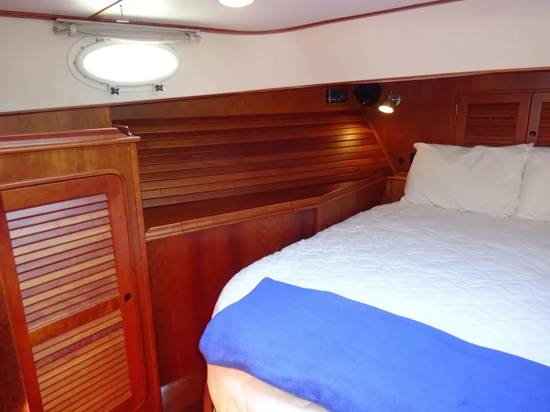 Slide: The Image of Cabin interior of 2002 Hinckley Talaria 44 FB with wooden paneling and cozy bedding. - 28